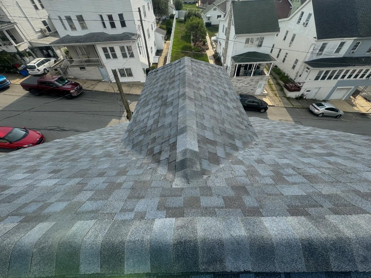 Roof tear-off and architectural shingle replacement project showing old shingle removal and new roof installation